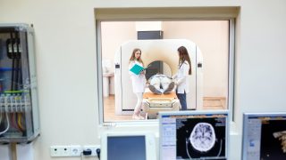 MRI machine and screens with doctor and nurse